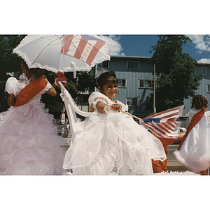 The Reina Infantil waves a Puerto Rican flag from a parade float