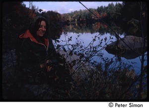 View of a woman seated by the edge of a pond, Tree Frog Farm commune