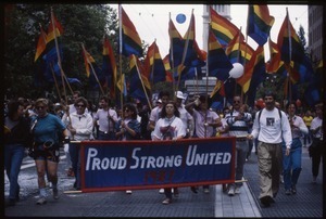 Marchers in the San Francisco Pride Parade with pride flags and banner 'Proud / Strong United 1987'