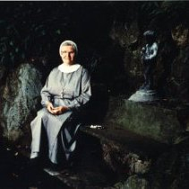 Nun sitting by Statue