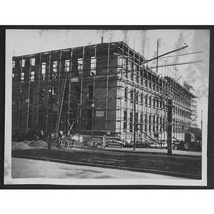 Building frame with ladder and partially constructed walls with windows