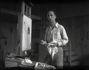 Norman Rockwell standing at an easel, painting
