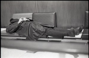 Man sleeping on bench while waiting at JFK airport