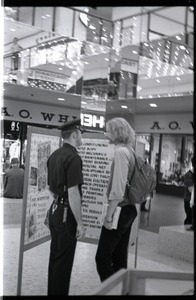 Free Spirit Press crew member talking with police office in an indoor mall