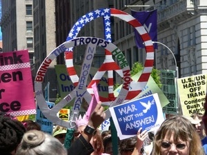Antiwar marchers in the streets of New York with signs and banners opposing the war in Iraq, 'Bring the troops home now'