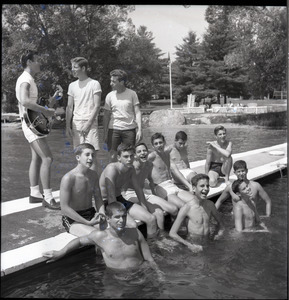 Camp Arcadia: campers at a swimming pool, one playing a guitar