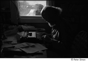 Ram Dass at typewriter: Ram Dass typing, with a portrait of Neem Karoli Baba in the background