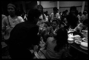 Cambodian New Year's celebration: presenting a bowl of money to seated man