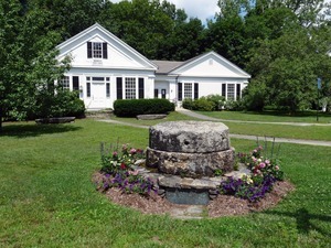 Warwick Free Public Library: exterior of the front of the library, with grist millstones in foreground