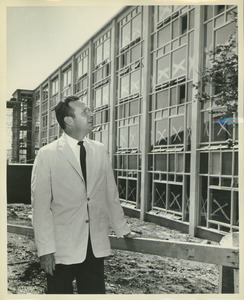 Fred Virgil Cahill standing outdoors in front of Bartlett Hall during its construction