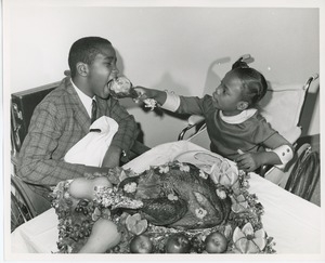 Donna Robinson feeding a turkey leg to Norris Powell