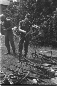 U.S. troops inspecting Chinese weapons captured from the Vietcong at Bau Bang.