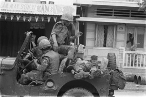 Marines load their wounded on Jeep in street fighting; Saigon.