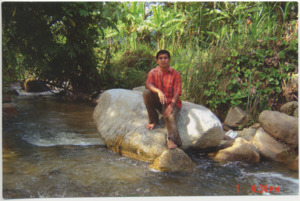 A photograph of Mohamed Yakob sitting on a rock in a forest in Malaysia, 2009