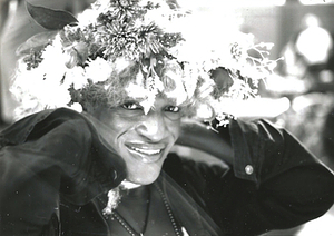 A Photograph of Marsha P. Johnson Posing for the Camera Wearing a Flower Headpiece