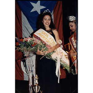 Yaritza Gonzalez, Miss Festival Puertorriqueño, wears a crown and sash and holds a bouquet of flowers