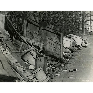 Broken crates, appliances, and rubbish piled along the side of Dacia Street, off of Quincy Street, in Roxbury, Mass.