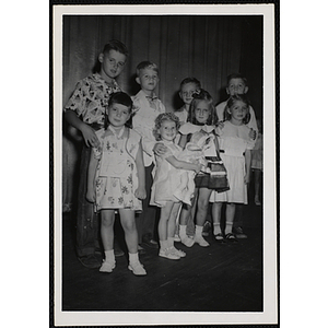 Four winners of the Little Sister Contest and their brothers posing on the stage