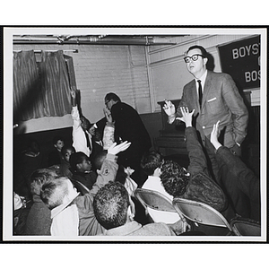 A man takes questions from an audience of boys