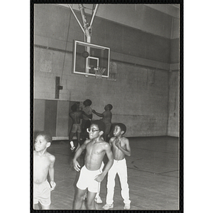 Men and boys play basketball in a gymnasium