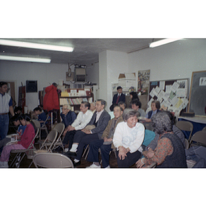 You King Yee and other members of the Chinese Progressive Association sit in chairs at the organization's office during a holiday party