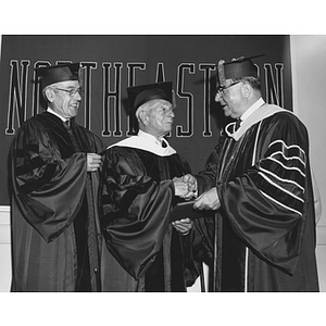 President Knowles shakes hands with Reuben Gryzmish, an honorary degree recipient