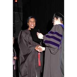 Faculty member presents student with certificate at School of Nursing convocation