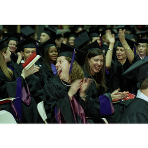 School of Law graduates smiling and clapping at commencement