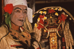 Bali temple dance performer next to Rangda mask