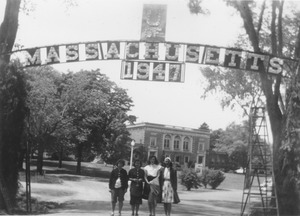 Students standing beneath the altered campus name arch