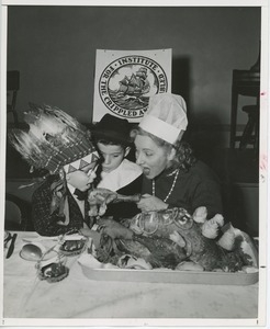 Connie Boswell with young clients in costume eating turkey