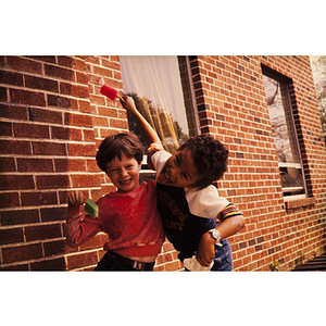 Boys posing outside a building holding popsicles