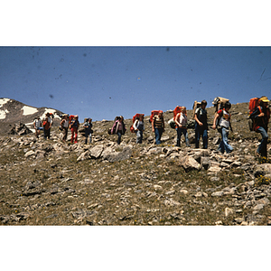 Youth hiking in line along ridge of hill