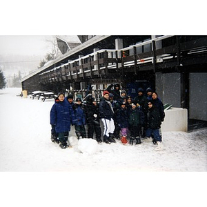 Group portrait of the participants of an Inquilinos Boricuas en Acción-sponsored ski trip standing outside in the snow.