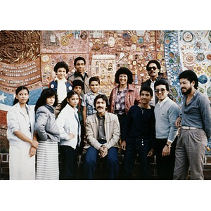 Group portrait of men, women, and children standing in front of the ceramic tile mural in the Plaza Betances.
