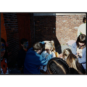 A girl has her face painted at a carnival