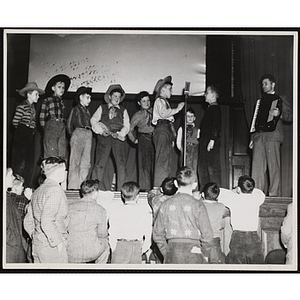 The Beverly Hillbillies perform on a stage before an audience of boys