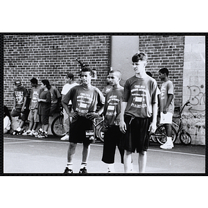 Three players stand on the court during a Chelsea Housing Authority Basketball League game