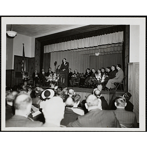 Frederic C. Church speaks at the podium as the audience looks on at the dedication and cornerstone laying ceremony for the Charles Hayden Memorial Clubhouse in South Boston