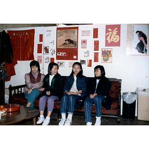 Young women sit on a couch at the Chinese Progressive Association office during a turkey dinner hosted by the organization to celebrate the Chinese New Year