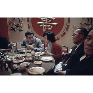 Suzanne Lee sits with three other men while eating at a restaurant table during a Chinese Progressive Association gathering