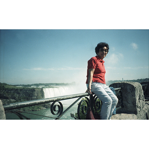 Woman sits on a fence overlooking Horseshoe Falls