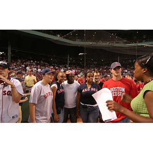 Six of the Torch Scholars stand on the field at Fenway Park