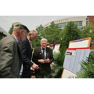 Three men look at plans for the Veterans Memorial at the groundbreaking ceremony