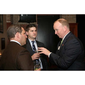 Jack Moynihan converses with two men at the Northeastern University New