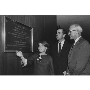 Young woman gesturing to the Stetson Hall plaque