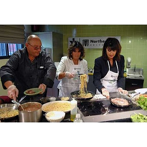 Two chefs cook with Philomena Mantella when the Torch Scholars visit the Exhibition Kitchen