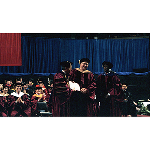 President Freeland presents an honorary degree to Neal F. Finnegan as his escort, Harry T. Daniels, stands by