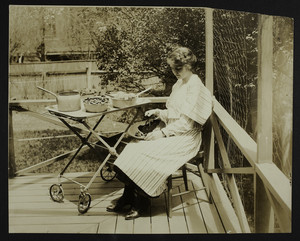 Woman on a patio with a tea wagon, location unknown, undated