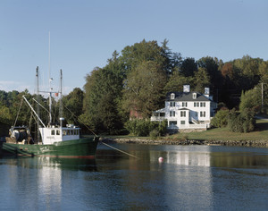 View of exterior from river with a boat in the foreground, Sayward-Wheeler House, York Harbor, Maine